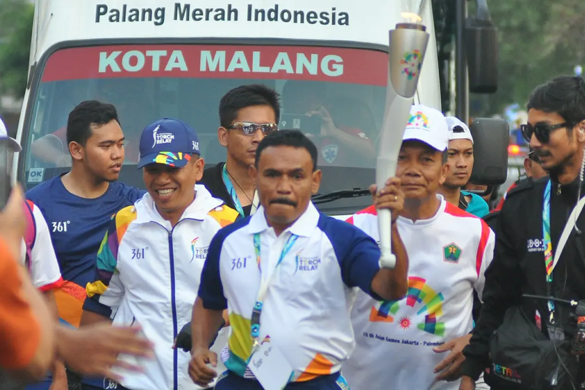 FOTO: Legenda Tinju Indonesia Bawa Obor Asian Games 2018 Melintasi Kota Malang