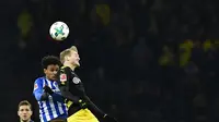 Gelandang Hertha Berlin Valentino Lazaro berebut bola dengan pemain Borussia Dortmund, Andre Schuerrle dalam lanjutan Bundesliga di Olympiastadion Berlin, Sabtu (20/1). Dortmund hanya mampu bermain imbang 1-1 melawan Hertha Berlin. (Tobias SCHWARZ/AFP)