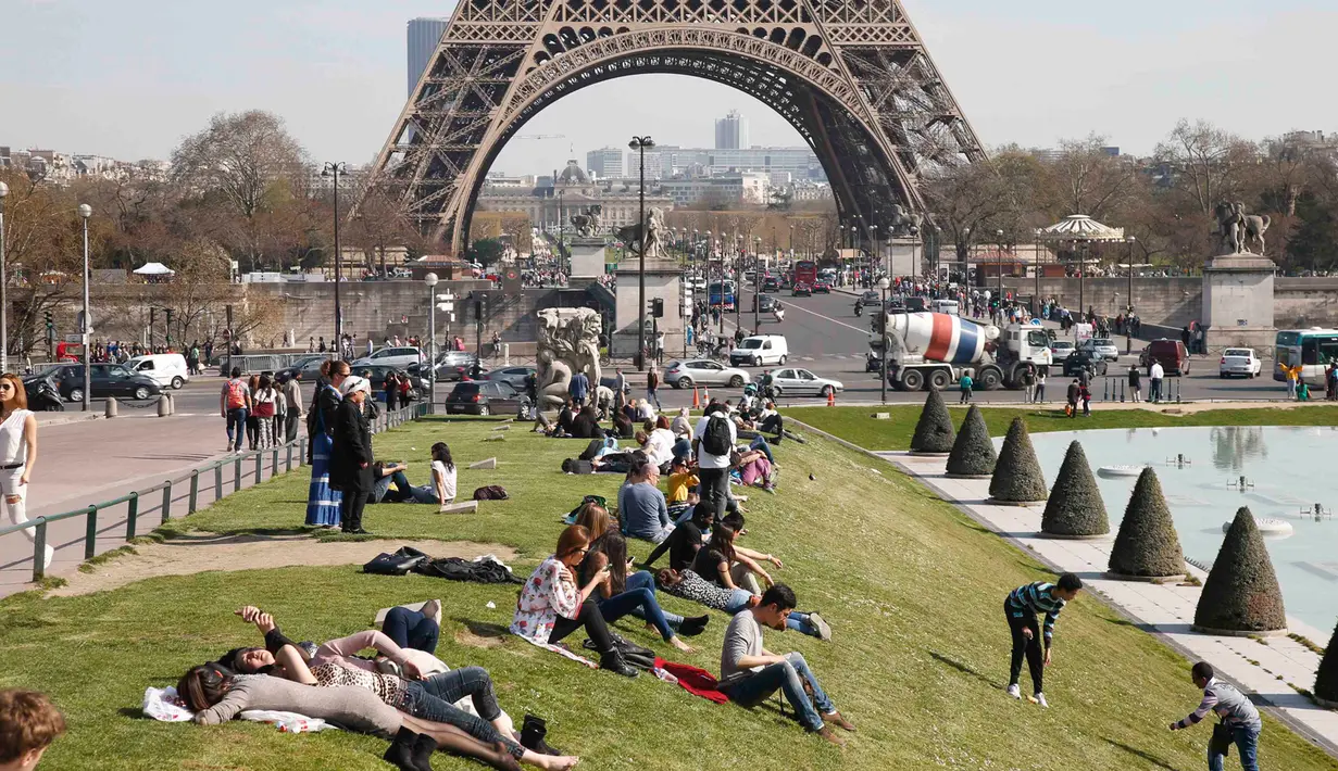 Sejumlah pengunjung sedang menikmati musim semi yang hangat dan cerah di Trocadero square di dekat menara Eiffel, Paris, Kamis (9/4/2015). (REUTERS/Charles Platiau)