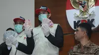 Petugas KPK menunjukkan barang bukti hasil operasi tangkap tangan terhadap Bupati Jombang, Nyono Suharli Wihandoko di Gedung KPK, Jakarta, Minggu (4/2). KPK menyita uang Rp 25,5 Juta dan 9.500 US Dollar. (Liputan6.com/Helmi Fithriansyah)