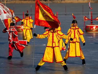 Seniman Tiongkok yang mengenakan kostum tradisional melakukan permainan es pada hari kedua perayaan Tahun Baru Imlek di danau beku di Taman Yuanmingyuan, Beijing, China, Senin (23/1/2023). Tahun Baru Imlek adalah hari libur tahunan terpenting di China. (AP Photo/Andy Wong)