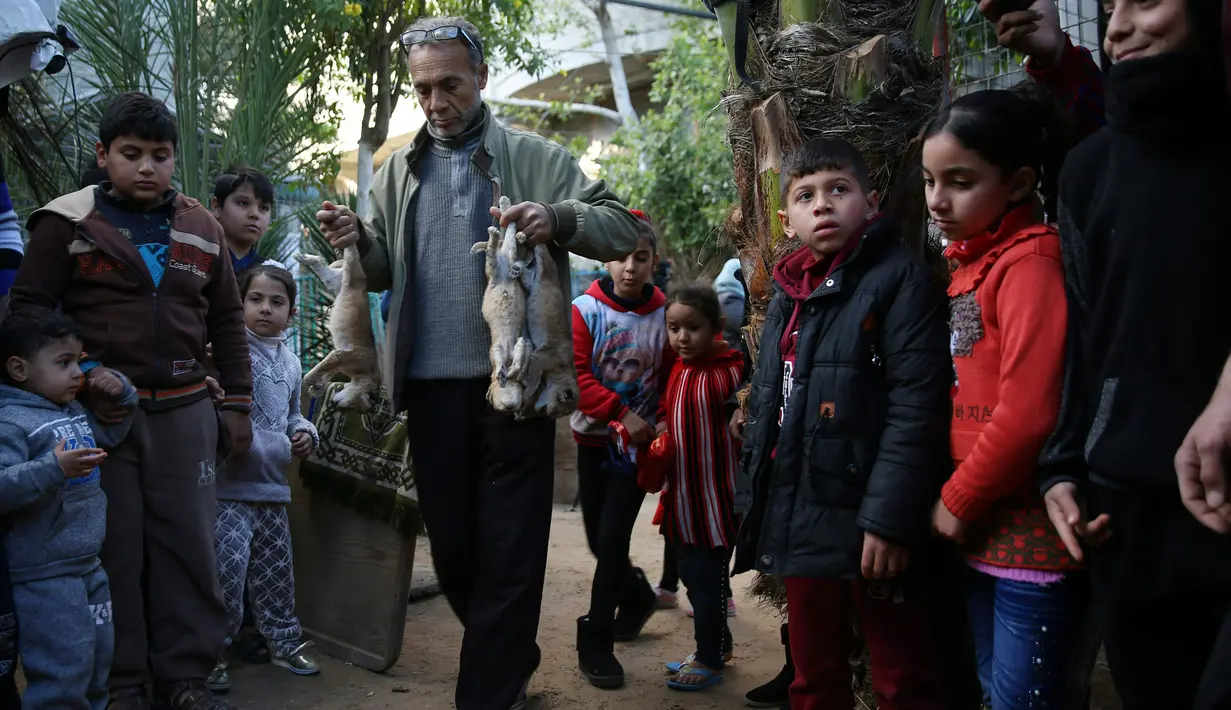 Pemilik kebun binatang Fathi Jumaa membawa mayat empat anak singa sebelum dikubur di kebun binatangnya di kamp pengungsi Rafah, Gaza (18/1). Fathi mengatakan ia menutupi sangkar singa-singa dengan selimut jelang badai musim dingin. (AP Photo/Adel Hana)