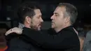 Pelatih Barcelona, Hansi Flick (kanan) bersalaman dengan pelatih Atletico Madrid, Diego Simeone dalam laga leg 1 semifinal Copa del Rey 2024/2025 di Estadi Olimpic Lluis Companys, Barcelona, Rabu (26/02/2025) dini hari WIB. (AFP/Lluis Gene)