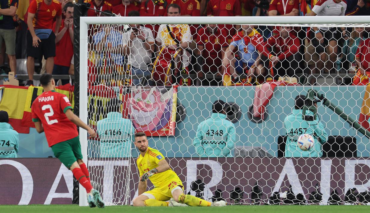 Achraf Hakimi. Bek kanan Maroko berusia 24 tahun yang kini bermain bersama PSG ini menjadi pemain keenam alias terbaru yang melakukan eksekusi penalti dengan gaya Panenka di Piala Dunia. Momen itu terjadi saat Maroko menang melalui adu penalti 3-0 (0-0) atas Sanyol pada babak 16 besar Piala Dunia 2022 (6/12/2022) di Qatar. Sebagai penendang ketiga, eksekusi penalti Panenka-nya mampu memperdaya kiper Spanyol, Unai Simon dan memastikan Maroko lolos ke babak perempatfinal. (AFP/Karim Jaafar)