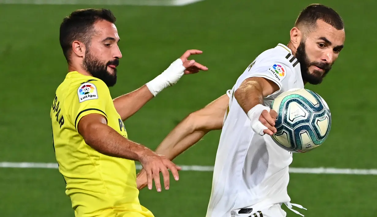Bek Villarreal, Mario Gaspar berebut bola dengan pemain depan Real Madrid Karim Benzema pada lanjutan kompetisi Liga Spanyol di Estadio Alfredo Di Stefano, Kamis (16/7/2020). Real Madrid memastikan diri menjadi juara La Liga musim 2019/20 setelah mengalahkan Villarreal 2-1. (GABRIEL BOUYS/AFP)