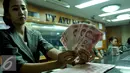 Petugas menunjukkan uang pecahan 100 Yuan di tempat penukaran uang, Jakarta, Kamis (13/8/2015). Kebijakan Tiongkok yang sengaja melemahkan (devaluasi) mata uang Yuan membuat Rupiah melemah terhadap dolar AS. (Liputan6.com/Johan Tallo)