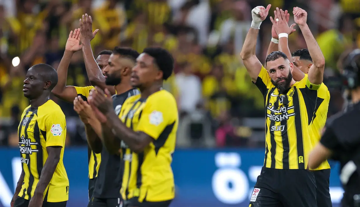 Karim Benzema bersama sejumlah pemain dari Ittihad FC merayakan kemenangan timnya atas Al Nassr pada laga lanjutan Liga Arab Saudi di King Abdullah Sports City, Jeddah, Arab Saudi, Sabtu (07/12/2024) dini hari WIB. (AFP)