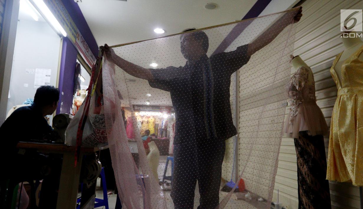 Seorang penjahit mengukur kain untuk dijadikan pakaian Lebaran, Pasar Mayestik, Jakarta Selatan, Senin (11/6). Masyarakat mulai membeli dan membuat baju pilihan mereka jelang Lebaran. (Liputan6.com/JohanTallo)