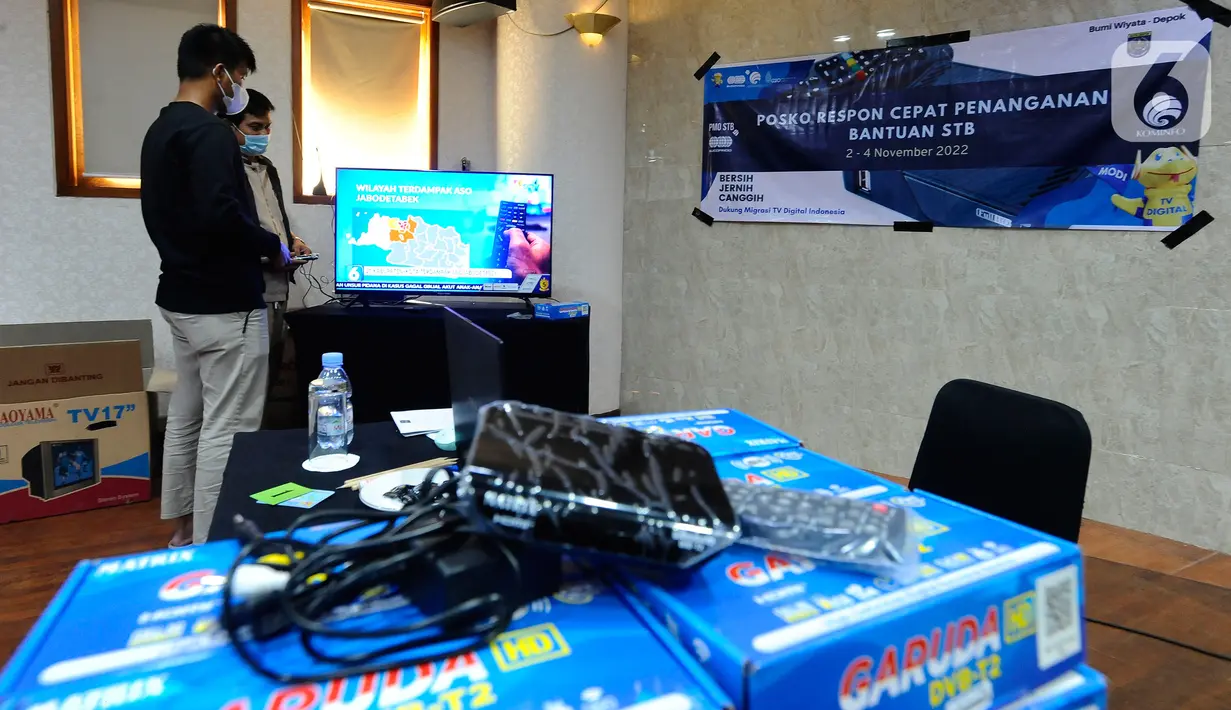 Petugas Kementerian Komunikasi dan Informatika (Kemenkominfo) menyampaikan penjelasan penggunaan alat Set Top Box (STB) yang dibagikan secara gratis kepada warga di Posko Respon Cepat Penanganan Bantuan STB di Hotel Bumi Wiyata, Depok, Jawa Barat, Rabu (2/11/2022). Kemenkominfo membuka posko penanganan bantuan STB sebagai perangkat konverter siaran TV digital ke televisi jenis analog bagi warga Jabodetabek yang akan mengikuti Analog Switch Off (ASO) di 2 November 2022 tengah malam. (merdeka.com/Arie Basuki)
