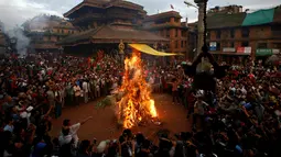 Sejumlah warga menyaksikan pembakaran boneka dari jerami yang dianggap sebagai setan  Ghantakarna selama Festival Ghantakarna di kota kuno Bhaktapur, Nepal, Senin (1/8). (REUTERS/Navesh Chitrakar)