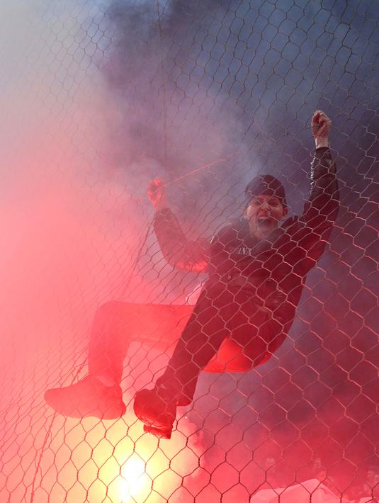 Seorang penggemar Bosnia-Herzegovina memanjat pagar saat merayakan timnya lolos ke Piala Dunia FIFA 2026 setelah memenangkan pertandingan final kualifikasi Eropa melawan Italia di stadion Bilino-Polje di Zenica pada 31 Maret 2026. (Elvis BARUKCIC/AFP)
