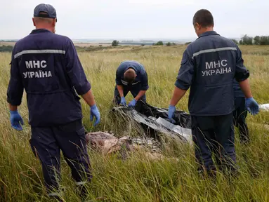 Tim penyidik Ukraina tampak menyiapkan kantong mayat untuk membawa jenazah dan sisa barang-barang dari puing Malaysia Airlines MH-17 (REUTERS/Maxim Zmeyev)