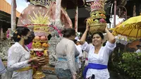 Umat Hindu membawa sesajen saat Hari Raya Galungan di sebuah pura di Bali, Rabu (4/1/2023). Hari Galungan juga menjadi hari di mana umat Hindu memperingati terciptanya alam semesta jagad raya beserta seluruh isinya. (AP Photo/Firdia Lisnawati)