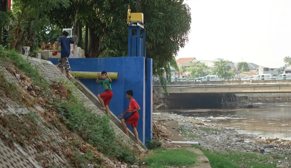 Anak-anak bermain di bantaran Sungai Ciliwung yang mengering, kawasan Kampung Melayu, Jakarta, Jumat (8/11/2019). Curah hujan yang tidak menentu menyebabkan sebagian bantaran Ciliwung masih mengalami kekeringan. (Liputan6.com/Immanuel Antonius)