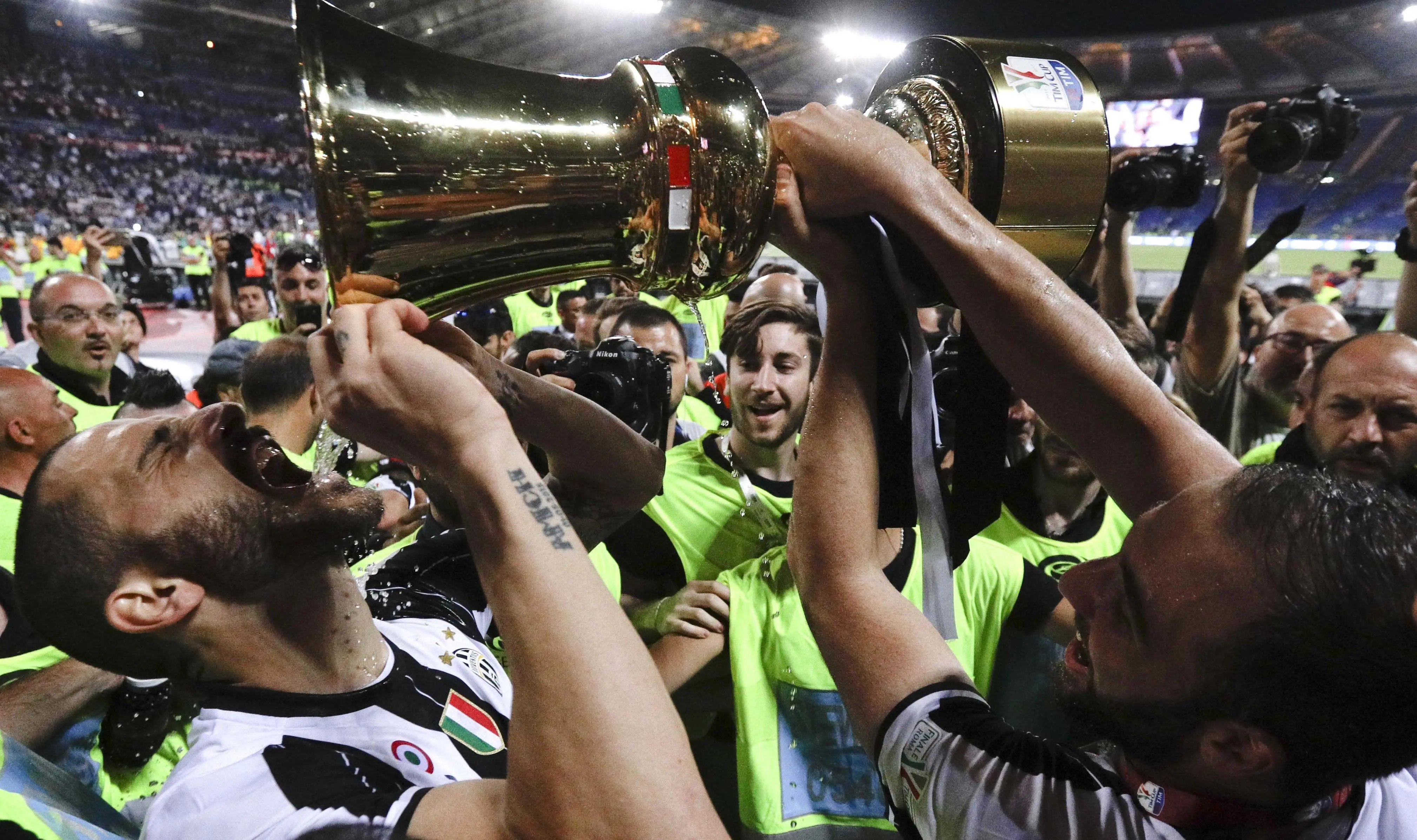 Gaya pemian Juventus, Leonardo Bonucci saat minum dari trofi juara Copaa Italia 2016-2017 usai mengalahkan Lazio di Roma Olympic stadium, (17/5/2017). Juventus menang 2-0. (AP/Gregorio Borgia)