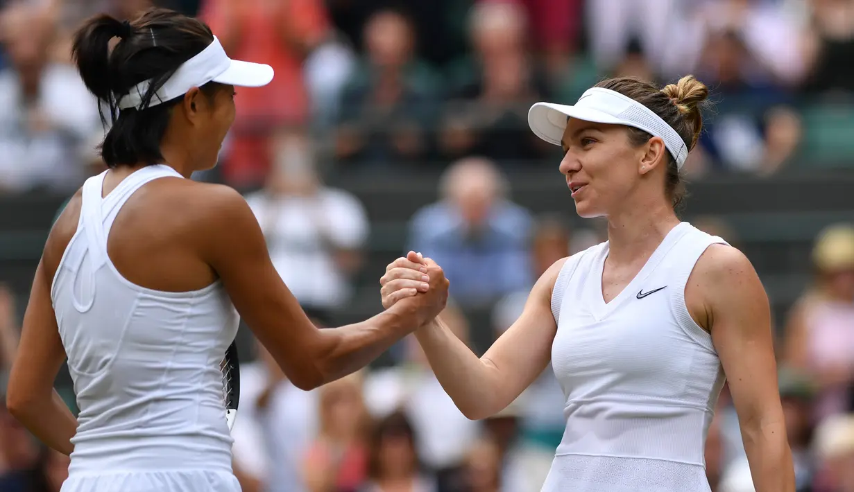 Petenis Rumania, Simona Halep berjabat tangan dengan petenis China, Shuai Zhang usai bertanding pada perempat final Grand Slam Wimbledon di London, Selasa (9/7/2019). Halep mengalahkan petenis non-unggulan asal China dengan memetik kemenangan 7-6, 6-1. (GLYN KIRK / AFP)
