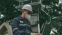Ilustrasi petugas PLN Icon Plus sedang melakukan pemeriksaan jaringan internet untuk meningkatkan keandalan jaringan.