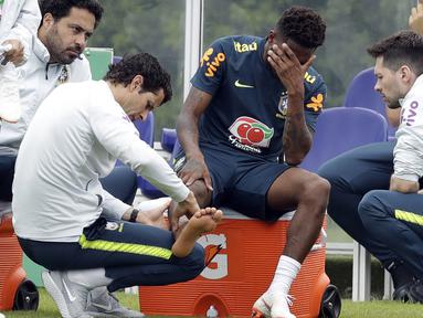Pemain Brasil, Fred menahan sakit saat diperiksa dokter tim di lapangan latihan Tottenham Hotspur football club, Inggris, (7/6/2018). Fred mengalami masalah di engkel kaki. (AP/Matt Dunham)