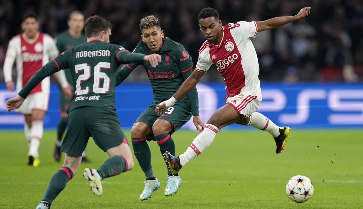 Bek Ajax Amsterdam Jurrien Timber berebut bola dengan pemain Liverpool Roberto Firmino dan Andrew Robertson pada matchday kelima Grup A Liga Champions 2022-2023 di Johan Cruiff Arena,  Kamis (27/10/2022) dini hari WIB. Liverpool saat ini menempati peringkat kedua klasemen Grup A Liga Champions dengan raihan 12 poin, sedangkan Ajax duduk di posisi ketiga via catatan tiga poin. (AP Photo/Peter Dejong)
