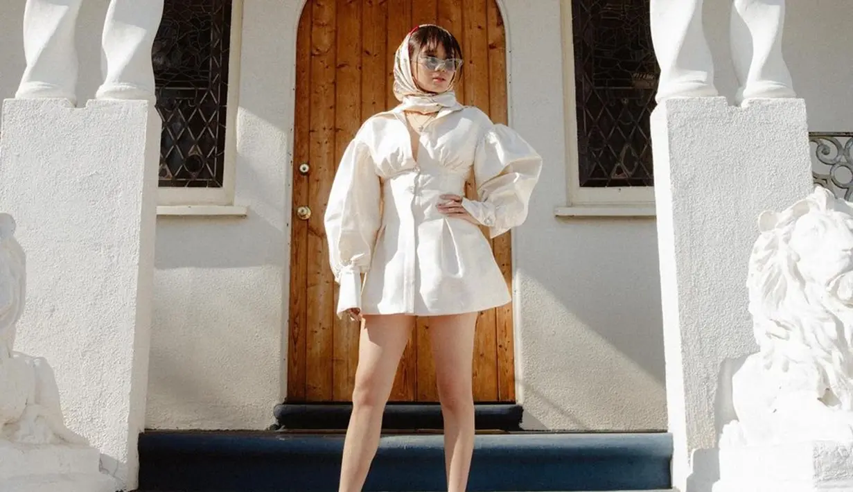 Outfit Niki Zafanya dengan dress berwarna putih ini juga tak liput dari sorotan publik. Pasalnya, ia tampil dengan gaya cukup unik menggunakan kacamata model cat eyes serta syal senada. (Liputan6.com/IG/@nikizefanya)
