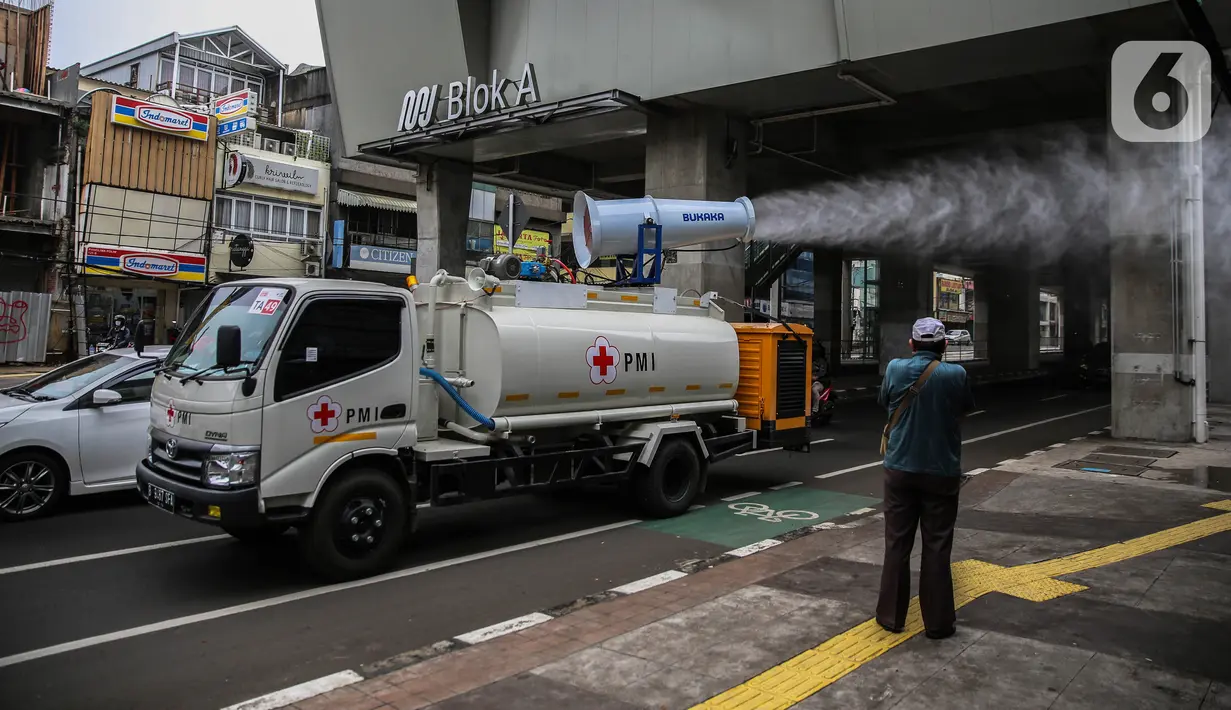 Petugas PMI dengan mobil gunners spraying menyemprotkan cairan disinfektan di kawasan Jalan Blok A, Jakarta, Kamis (30/4/2020). Untuk mencegah penyebaran COVID-19, PMI melakukan penyemprotan disinfektan berskala besar di wilayah DKI dengan memanfaatkan momen PSBB. (Liputan6.com/Faizal Fanani)