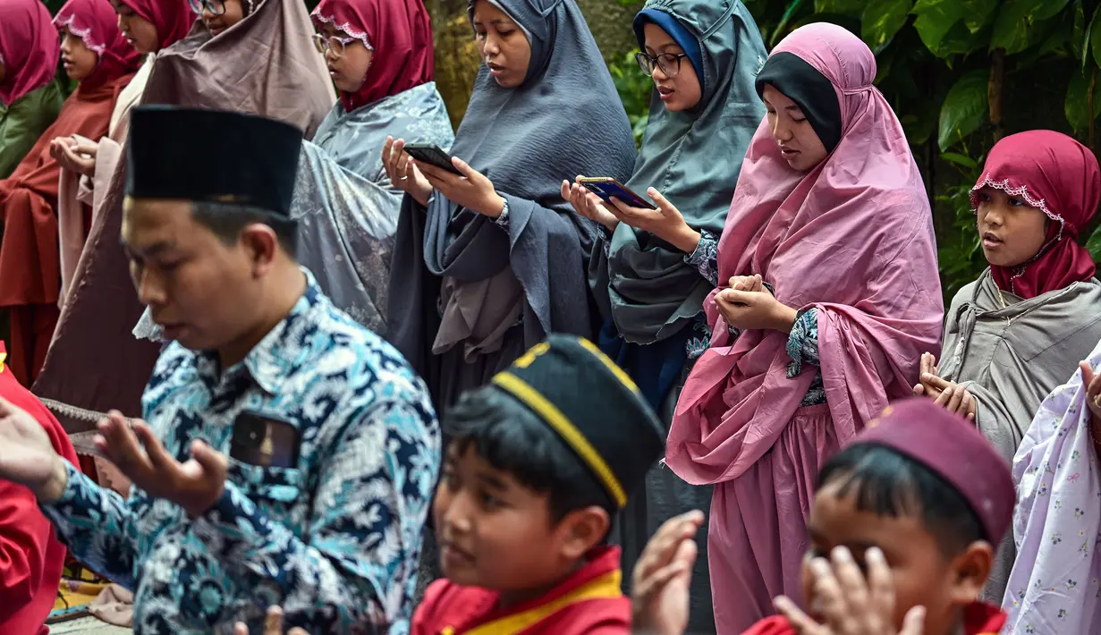 Sejumlah pelajar dan guru dari pondok pesantren Muhammadiyah mengikuti salat Istisqa untuk memohon turunnya hujan di tengah kekeringan berkepanjangan akibat fenomena El Niño di Surabaya, Jawa Timur, Kamis (22/10/2026). (JUNI KRISWANTO/AFP)