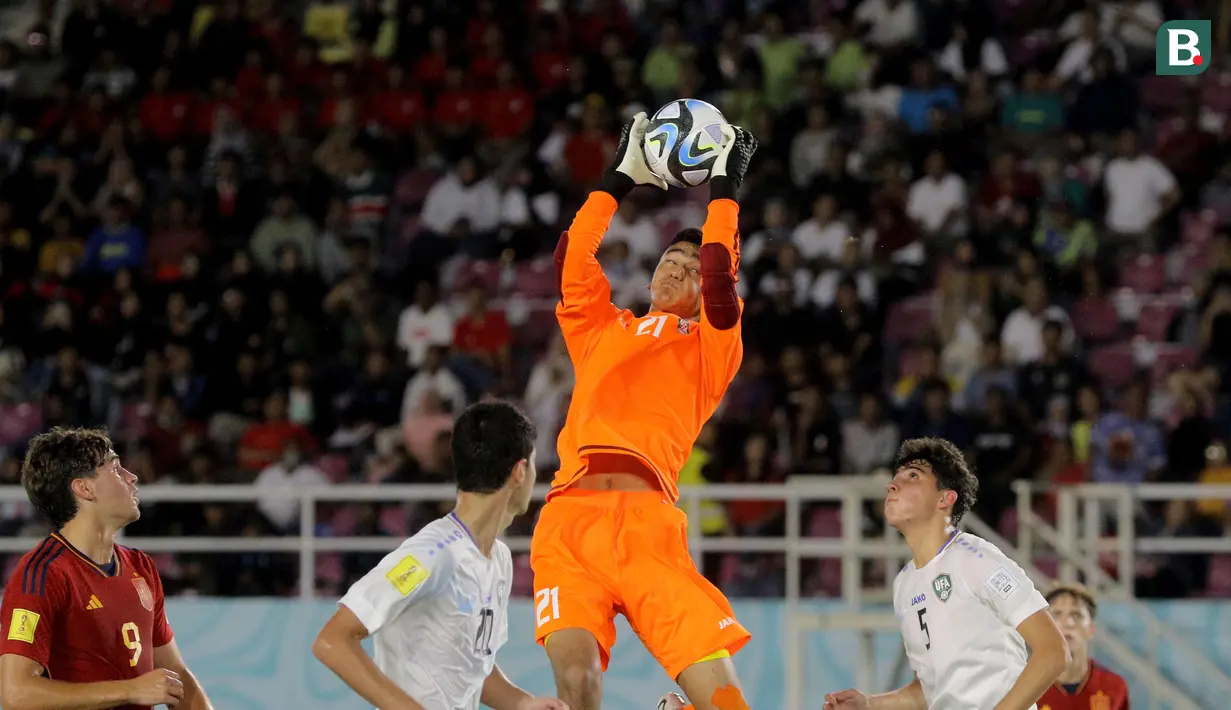 Pemain Timnas Uzbekistan U-17, Muhammadyusuf Sobirov (tengah) berhasil mengamankan bola di udara dari jangkauan pemain Timnas Spanyol U-17 dalam laga pamungkas Grup B Piala Dunia U-17 2023 yang berlangsung di Stadion Manahan, Solo, Kamis (16/11/2023) sore WIB. (Bola.com/Arief Bagus Prasetiyo)