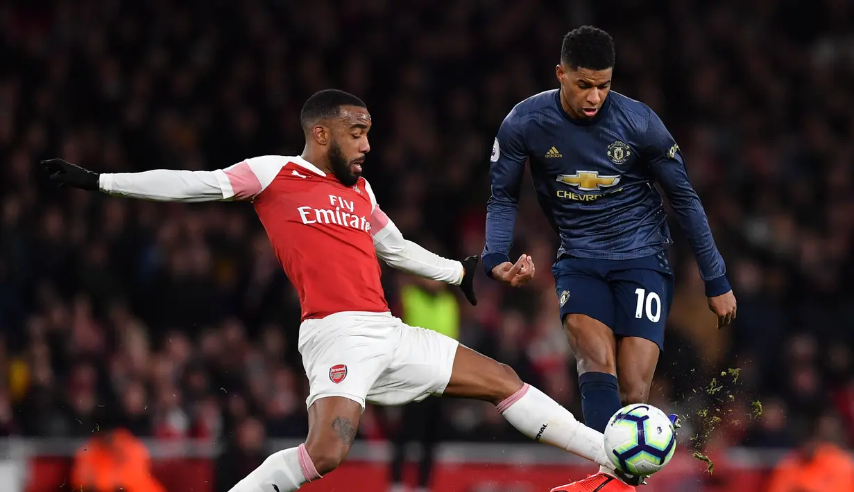 Duel antara Marcus Rashford dan Lacazatte pada laga lanjutan Premier League yang berlangsung di Stadion Emirates, London, Minggu (10/3). Arsenal menang 2-0 atas Man United. (AFP/Ben Stansall)