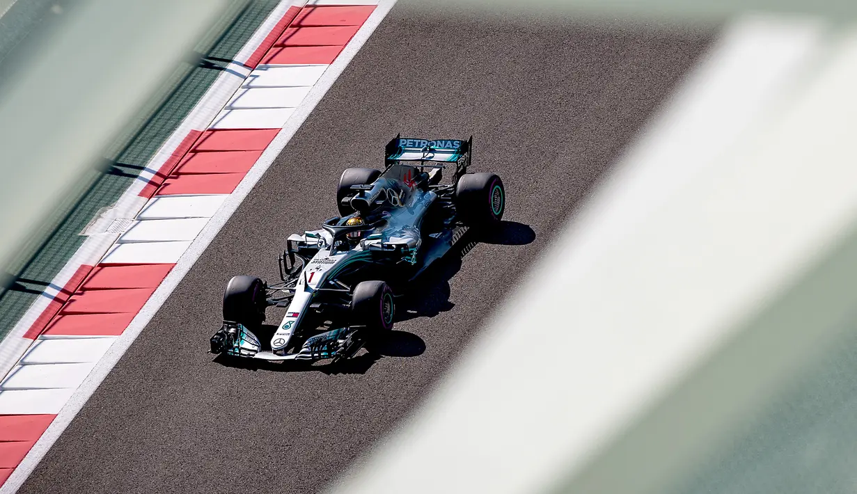 Pembalap Mercedes, Lewis Hamilton mengendarai mobilnya saat sesi latihan pertama jelang GP F1 Abu Dhabi di Sirkuit Yas Marina, Jumat (23/11). Sebastian Vettel tercatat menjadi orang terakhir yang menggunakan nomor 1 dalam balap F1. (Andrej ISAKOVIC/AFP)