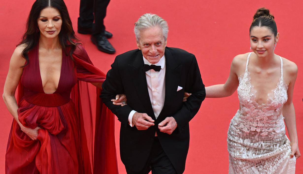 Remaja berusia 20 tahun tampak dewasa di samping orang tuanya dalam balutan gaun renda putih Elie Saab. (AFP/Antonin Thuillier)