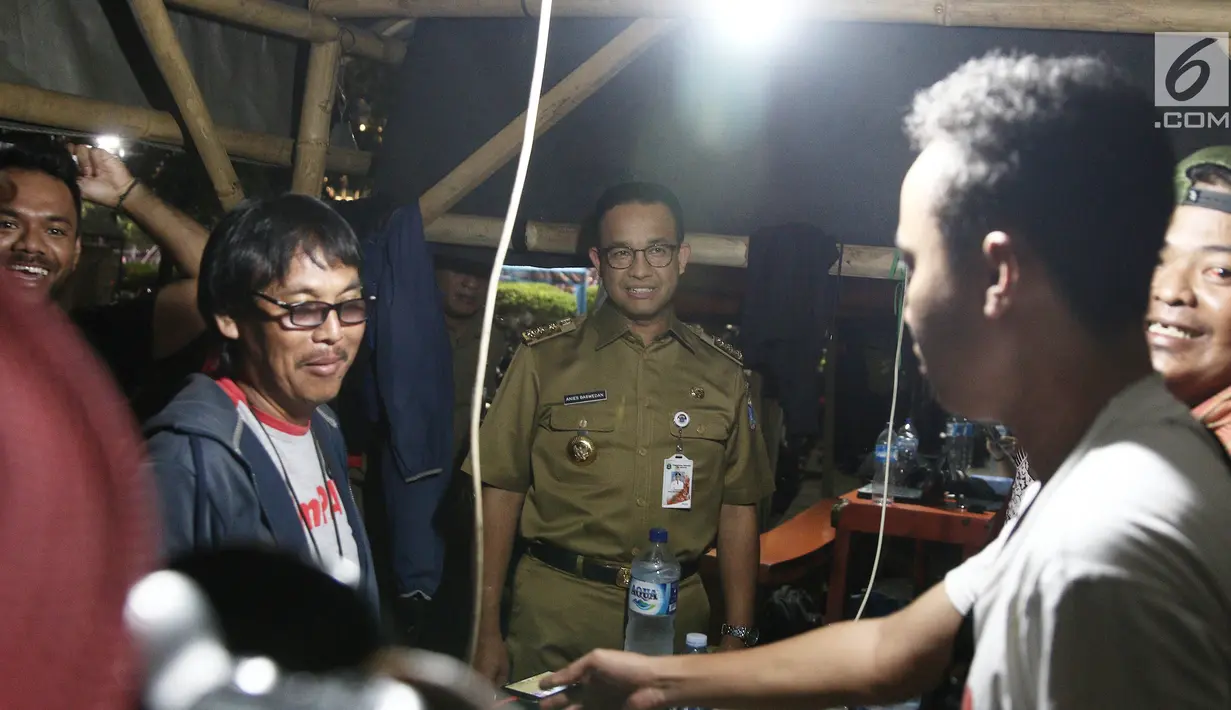 Gubernur DKI Jakarta Anies Baswedan berbincang dengan Pewarta Foto di Posko Pewarta Foto Bundaran HI, Jakarta, Selasa (13/11). Kedatangan Anies untuk meninjau fasilitas masyarakat di kawasan Bundaran HI. (Liputan6.com/Herman Zakharia)