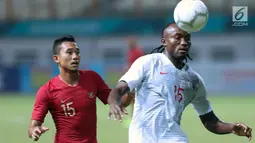 Pemain Timnas Indonesia, Ricky Fajrin (kiri) berebut bola dengan pemain Hong Kong pada laga uji coba internasional di Stadion Wibawa Mukti, Cikarang, Selasa (16/10). Babak pertama, Indonesia unggul 1-0. (Liputan6.com/Helmi Fithriansyah)