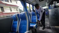 Petugas mengecek kondisi kursi dalam bus Transjabodetabek Premium milik Perum PPD saat menunggu calon penumpang di Tamini Square, Jakarta, Kamis (14/12). (Liputan6.com/Faizal Fanani)