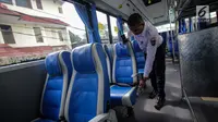 Petugas mengecek kondisi kursi dalam bus Transjabodetabek Premium milik Perum PPD saat menunggu calon penumpang di Tamini Square, Jakarta, Kamis (14/12). (Liputan6.com/Faizal Fanani)