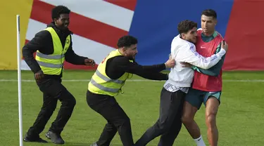 Seorang penggemar menempel pada penyerang Portugal Cristiano Ronaldo selama sesi latihan di Gutersloh, Jerman, Jumat, 14 Juni 2024. (AP Photo/Hassan Ammar)