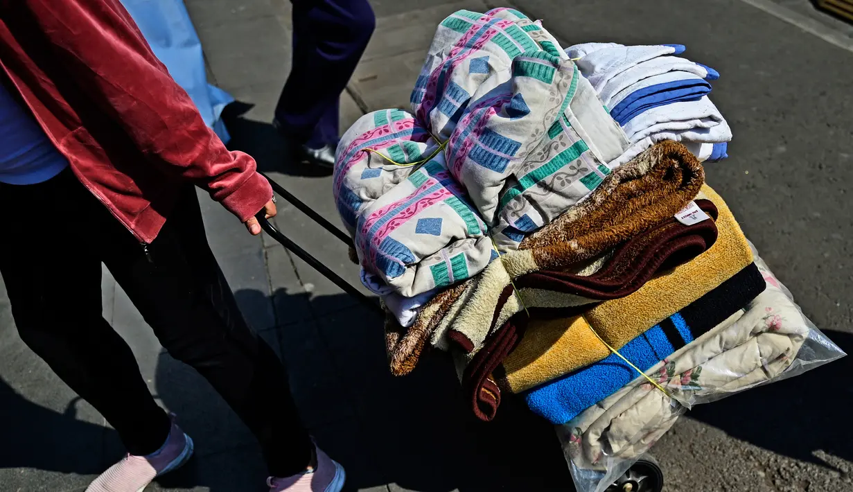 Seorang wanita mengantarkan selimut ke pusat donasi untuk membantu korban gempa magnitudo 7,8 yang melanda Turki dan Suriah di Mexico City, Meksiko, 8 Februari 2023. Korban tewas akibat gempa Turki dan Suriah naik di atas 11.700 pada hari Rabu ketika tim penyelamat berlomba untuk menyelamatkan korban yang terjebak di bawah puing-puing di tengah musim dingin. (Pedro PARDO/AFP)