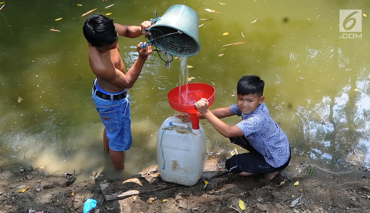 Dua anak Kampung Gamblok mengambil sisa air Kali Cihoe, Desa Ridomanah, Bekasi, Jawa Barat, Kamis (15/8/2019). Kemarau panjang sejak awal Ramadan memaksa warga mencari sisa air untuk diminum.