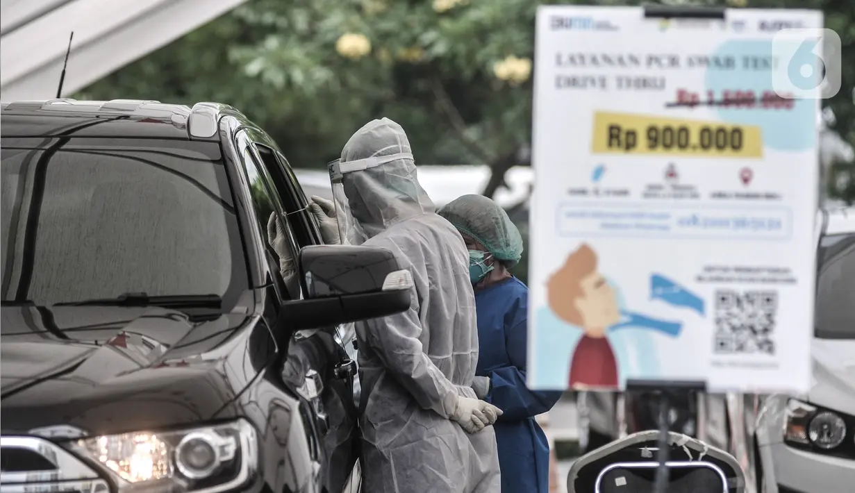 Tenaga kesehatan mengambil sampel lendir untuk tes usap PCR drive thru di halaman Rumah Sakit Pertamina Jakarta (RSPJ), Rabu (6/1/2021). Kegiatan tes usap drive thru di RSPJ digelar setiap hari mulai pukul 08.00 WIB- 16.00 WIB dengan tarif Rp900 ribu per orang. (merdeka.com/Iqbal Nugroho)