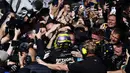 Pembalap Mercedes, Lewis Hamilton merayakan kemenangan bersama timnya setelah finis pertama di Formula 1 GP Inggris 2024 yang berlangsung di Sirkuit Silverstone, Inggris, Minggu (08/07/2024). (AFP/Benjamin Cremel)