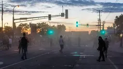 Demonstran bentrok dengan polisi saat unjuk rasa atas kematian George Floyd oleh polisi di luar Third Police Precinct, Minneapolis, Minnesota, Amerika Serikat, Rabu (27/5/2020). Pria kulit hitam, George Floyd, meninggal karena kehabisan napas setelah lehernya diduduki oleh polisi. (Kerem Yucel/AFP)