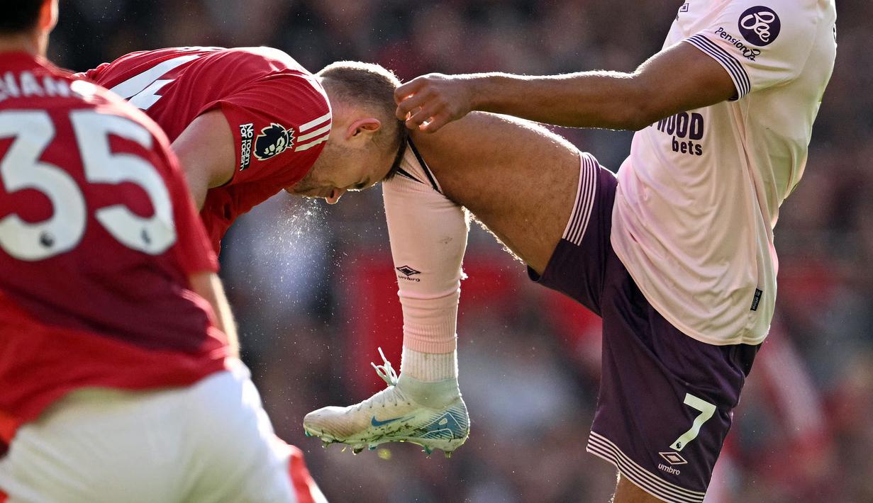 Pemain Manchester United, Matthijs de Ligt (kiri) berbenturan dengan lutut pemain Brentford, Kevin Schade saat laga lanjutan Liga Inggris 2024/2025 di Old Trafford, Manchester, Sabtu (19/10/2024). (AFP/Oli Scarff)