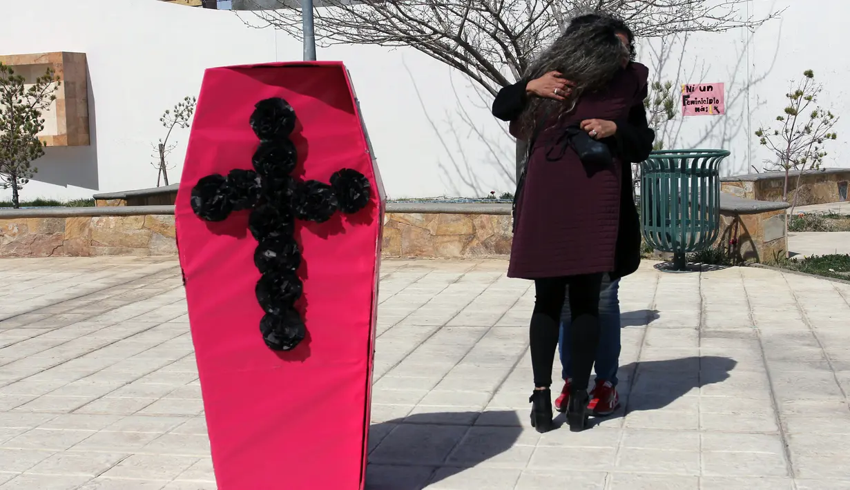 Dua aktivis berpelukan saat demonstrasi menghormati wanita yang dibunuh di Ciudad Juarez saat Hari Perempuan Internasional atau Women's Day di Jembatan Internasional Paso del Norte, Ciudad Juarez, Chihuahua, Meksiko, Rabu (7/3). (HERIKA MARTINEZ/AFP)