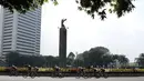 Para pebalap melewati patung Selamat Datang pada ajang Tour de Jakarta di Bundaran Hotel Indonesia, Jakarta, Sabtu (30/7/2016). (Bola.com/Nicklas Hanoatubun)