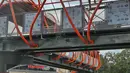 Pekerja menyelesaikan pembangunan jembatan penyeberangan orang (JPO) atau "Skywalk" di kawasan Kebayoran Lama, Jakarta, Sabtu (19/11/2022). Pemprov DKI Jakarta melalui Dinas Bina Marga DKI Jakarta membangun skywalk sepanjang 500 meter dengan desain dan cahaya artistik serta dilengkapi fasilitas lift juga eskalator. (Liputan6.com/Angga Yuniar)