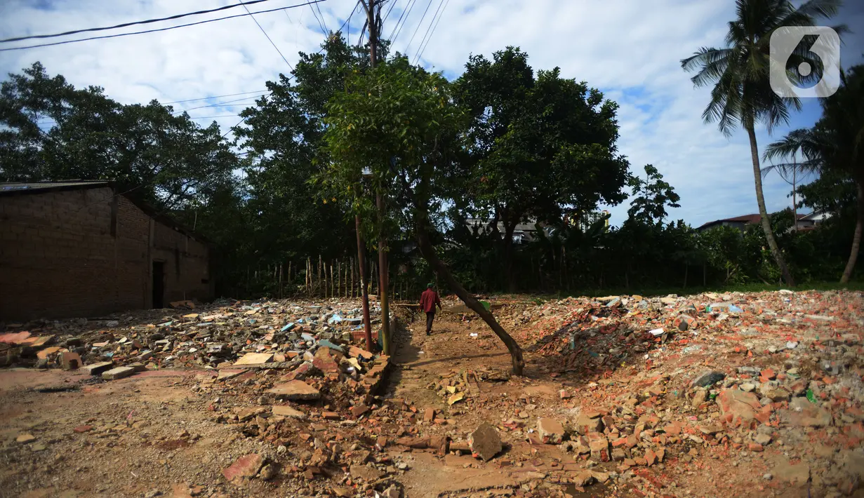Warga berjalan di dekat bongkaran rumah yang terdampak normalisasi sungai Ciliwung  Rawajati, Jakarta, Rabu (16/11/2022). Pemprov DKI Jakarta kembali melanjutkan normalisasi kali Ciliwung Kelurahan Rawajati menjadi prioritas penanganan banjir pada 2023.  Dengan luas lahan yang dibebaskan sebesar 4.780 meter persegi dengan jumlah 22 kk. (merdeka.com/Imam Buhori)