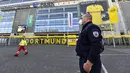 Petugas Keamanan dengan menggunakan masker berjaga di depan Stadion Signal Iduna Park, Jerman, Sabtu (4/4/2020). Stadion Borussia Dortmund ini dialihfungsikan menjadi tempat pusat pengujian COVID-19. (AP/Martin Meissner)