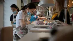 Seorang pelanggan menerima manikur di sebuah salon di Moskow pada 13 April 2022. Jauh dari konflik di Ukraina, musim semi telah tiba di Moskow dengan di permukaan setidaknya kehidupan tampak berjalan seperti biasa. Dengan akan segera berakhirnya musim dingin keras yang terkenal di Rusia, orang-orang Moskow memadati restoran dan teater, berkeliaran di galeri seni dan berjalan-jalan di bawah sinar matahari. (Natalia KOLESNIKOVA / AFP)