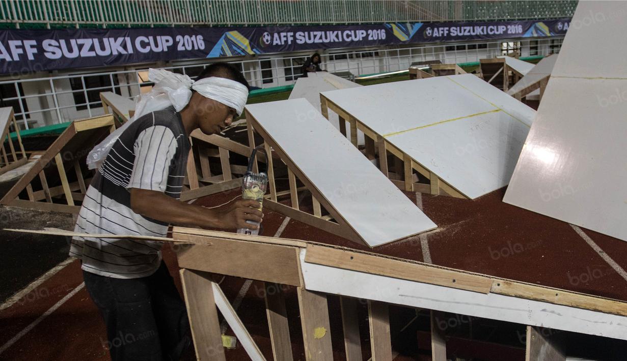 Pekerja membuat panggung saat persiapan jelang laga semifinal Piala AFF 2016 antara Timnas Indonesia melawan Vietnam di Stadion Pakansari, Jawa Barat, Jumat (3/12/2016). (Bola.com/Vitalis Yogi Trisna)