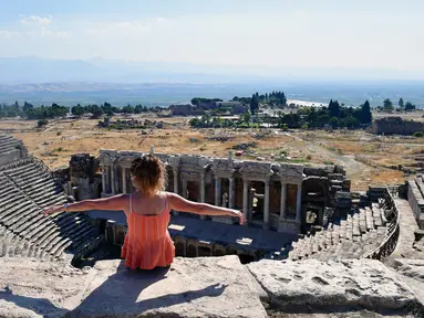 Seorang pengunjung duduk di reruntuhan kota kuno Hierapolis, Denizli, Turki, 6 Agustus 2020. Reruntuhan Hierapolis telah terdaftar sebagai Situs Warisan Dunia UNESCO. (Xinhua/Mustafa Kaya)