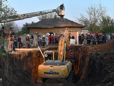 Kendaraan alat berat dikerahkan untuk menyelamatkan bocah 2 tahun yang jatuh di sumur kedalaman 16 meter di Desa Balta Sarata, Rumania, Selasa (25/4). (AFP PHOTO/DANIEL MIHAILESCU)